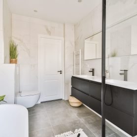 Interior of modern Stylish bathroom interior design with white toilet and tub, sinks and a large mirror above themlight bathroom with toilet